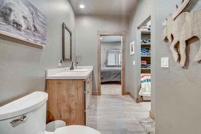 bathroom with vanity, hardwood / wood-style floors, and toilet