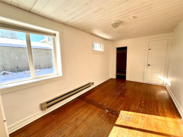 spare room with wood ceiling, a baseboard radiator, and dark hardwood / wood-style flooring