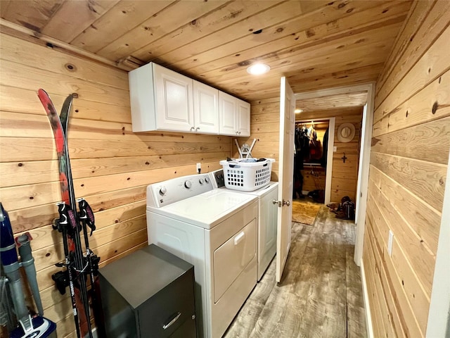 washroom with wood walls, cabinets, washer and dryer, light wood-type flooring, and wooden ceiling