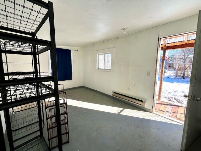 empty room featuring concrete flooring and a baseboard heating unit