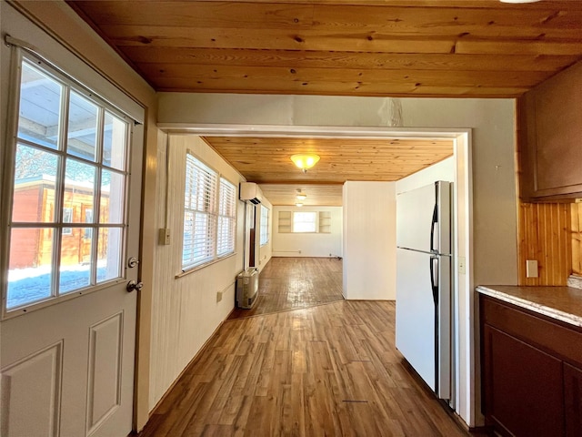 doorway with wooden ceiling, a wall mounted AC, and light wood-type flooring