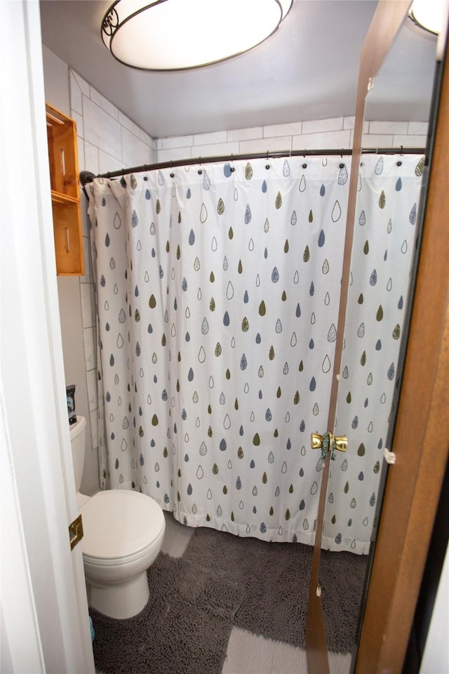 bathroom with toilet and walk in shower