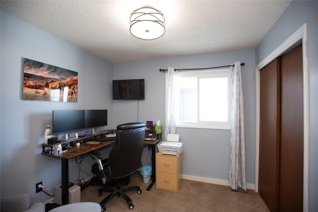 carpeted home office with a textured ceiling