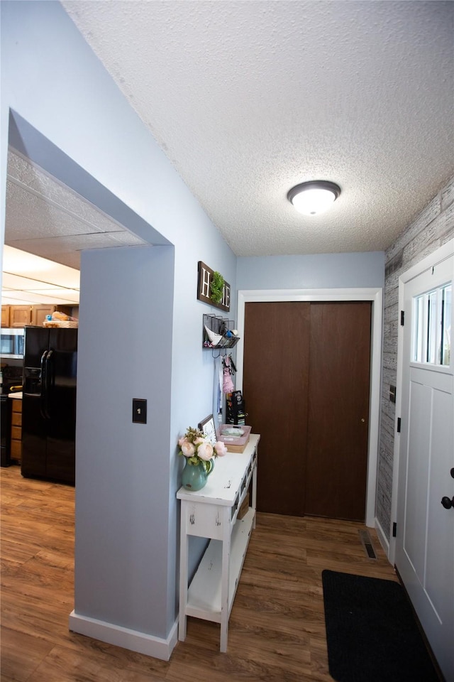 doorway featuring dark hardwood / wood-style floors and a textured ceiling