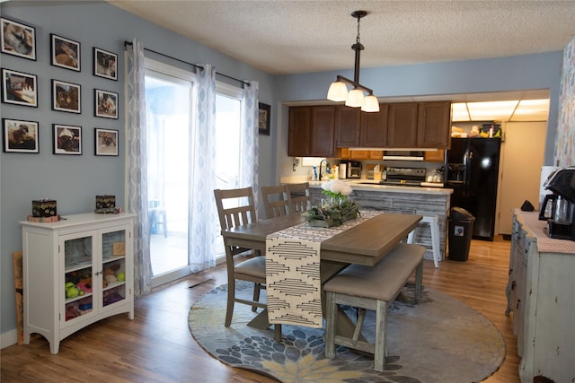 dining room with light hardwood / wood-style floors and a textured ceiling