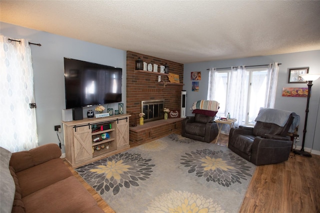 living room with hardwood / wood-style flooring, a fireplace, and a textured ceiling