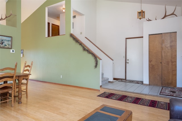 foyer entrance featuring hardwood / wood-style flooring and a high ceiling