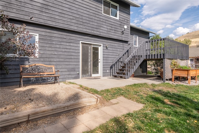 back of property with a wooden deck and a patio area