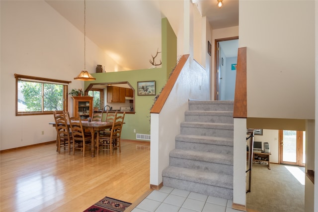 stairs featuring hardwood / wood-style flooring and a high ceiling