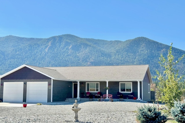 view of front of property featuring a porch, a mountain view, and driveway