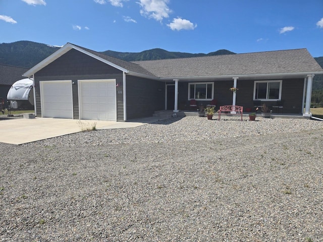 66 Moccasin Ln, Thompson Falls, MT 59873 - ranch-style home with covered porch, an attached garage, concrete driveway, and a mountain view
