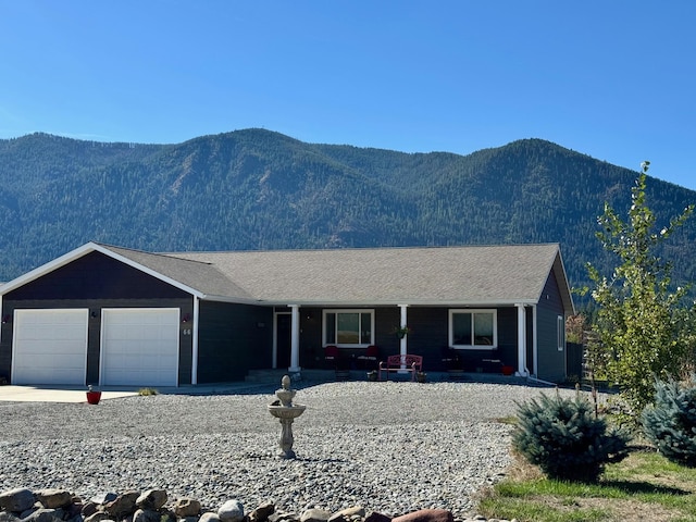 single story home featuring a garage, a mountain view, a porch, and concrete driveway