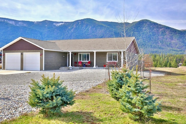 66 Moccasin Ln, Thompson Falls, MT 59873 - ranch-style home with covered porch, an attached garage, a mountain view, and concrete driveway