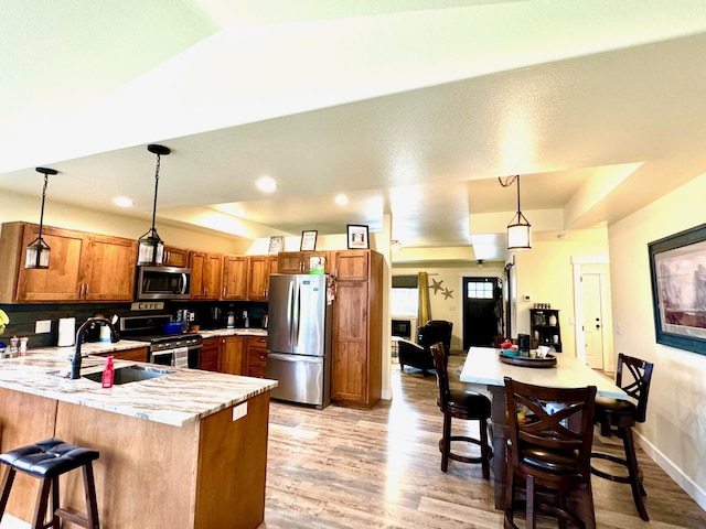 66 Moccasin Ln, Thompson Falls, MT 59873 - kitchen with stainless steel appliances, a peninsula, brown cabinets, a sink, and light wood-type flooring