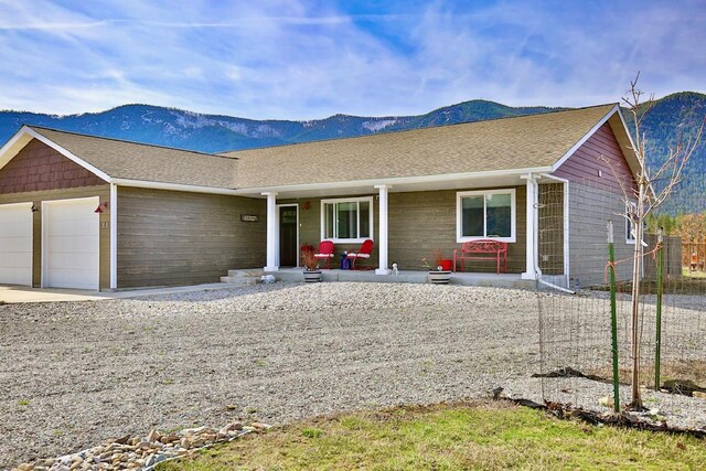 66 Moccasin Ln, Thompson Falls, MT 59873 - ranch-style house with a garage, a porch, a mountain view, and driveway
