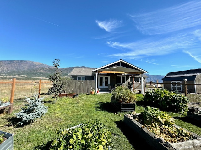 66 Moccasin Ln, Thompson Falls, MT 59873 - back of property featuring a vegetable garden, french doors, and a mountain view