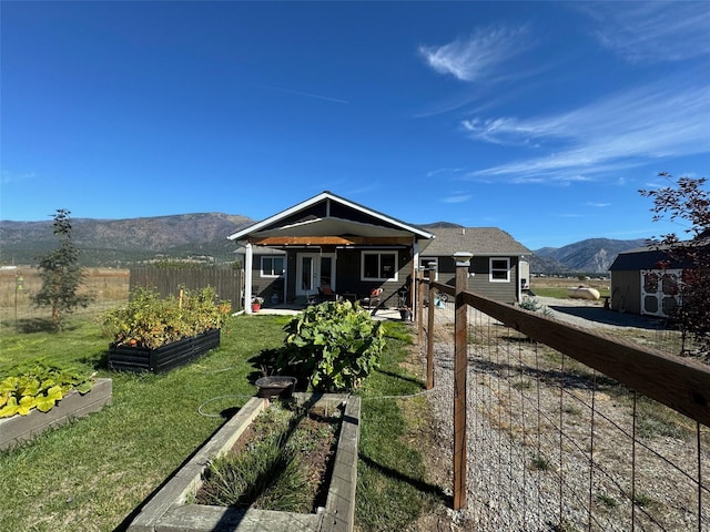 66 Moccasin Ln, Thompson Falls, MT 59873 - view of front of property featuring a vegetable garden, a mountain view, and french doors