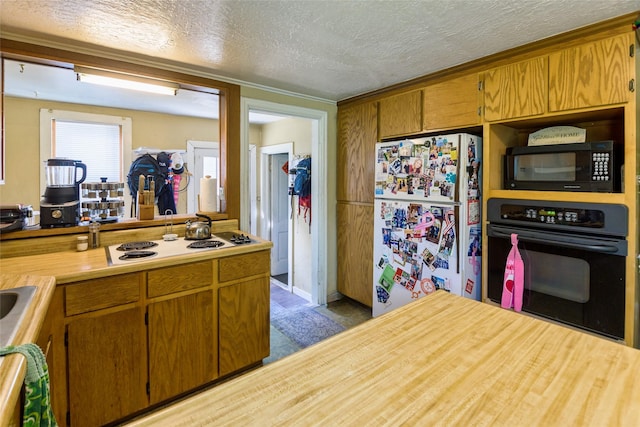 kitchen with crown molding, a textured ceiling, and black appliances