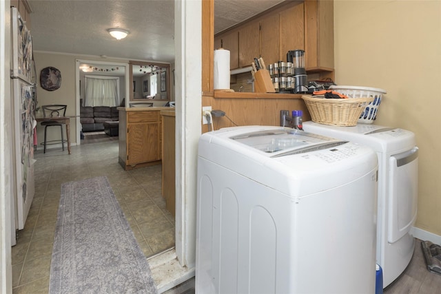 laundry room featuring light tile patterned floors, washer and clothes dryer, and a textured ceiling