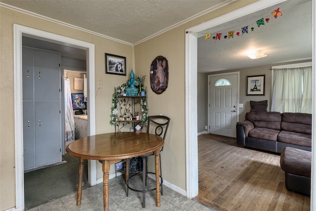 dining area with ornamental molding and a textured ceiling