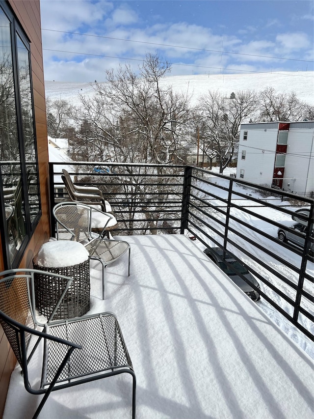 view of snow covered back of property