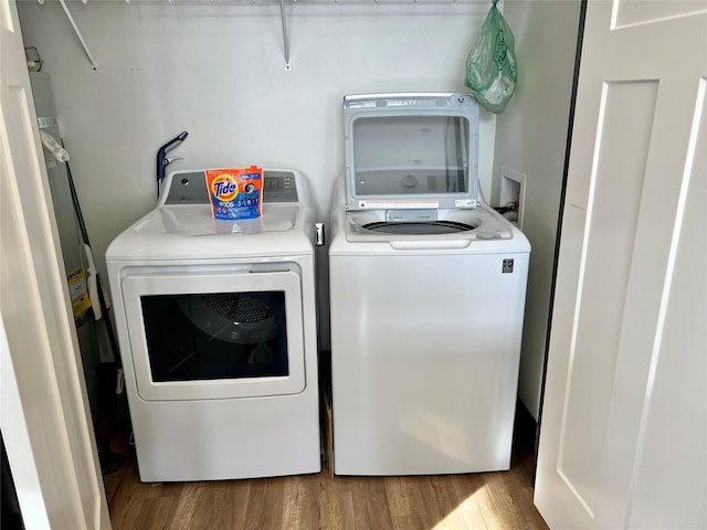 washroom featuring water heater, hardwood / wood-style floors, and washer and clothes dryer