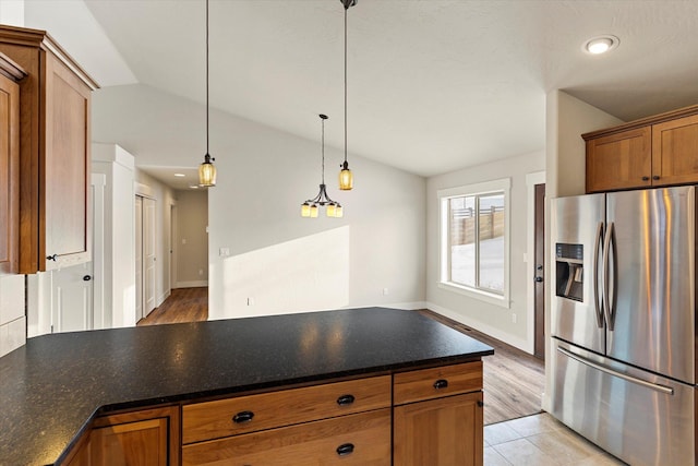 kitchen with stainless steel refrigerator with ice dispenser, vaulted ceiling, and pendant lighting