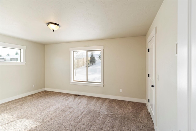 unfurnished bedroom with carpet flooring, multiple windows, and a textured ceiling