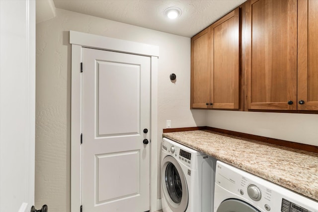 laundry room with cabinets, washing machine and clothes dryer, and a textured ceiling