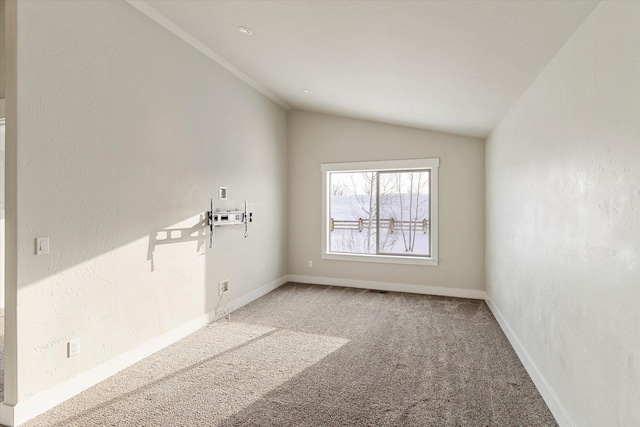 empty room featuring carpet floors and vaulted ceiling