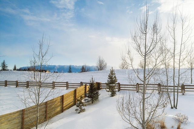 snowy yard featuring a rural view