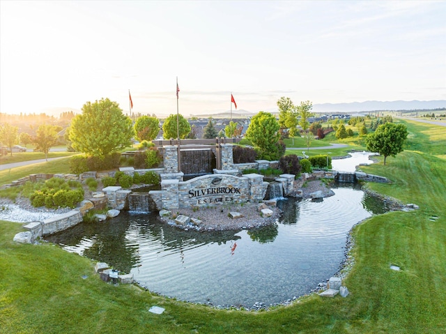 view of home's community with a water view and a yard