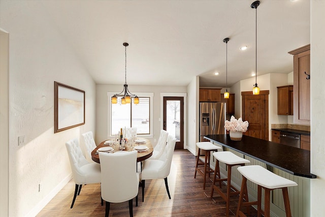 dining room featuring vaulted ceiling and dark wood-type flooring