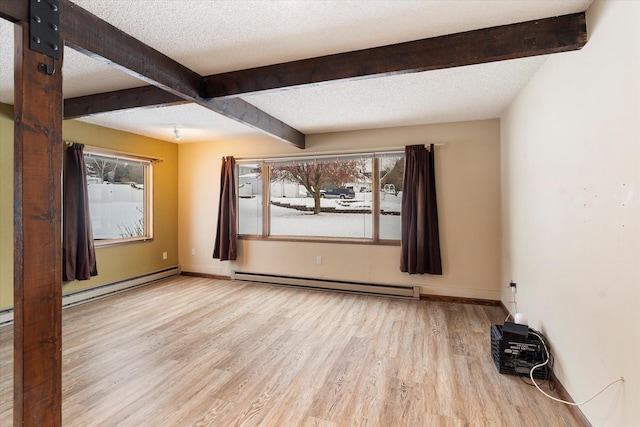 empty room with beamed ceiling, a baseboard radiator, and a textured ceiling