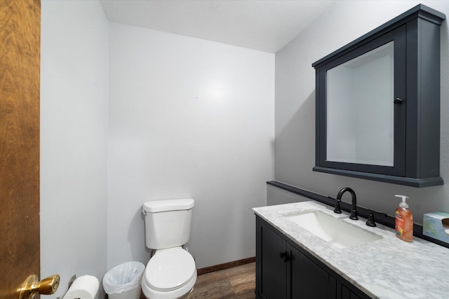 bathroom featuring hardwood / wood-style flooring, vanity, and toilet