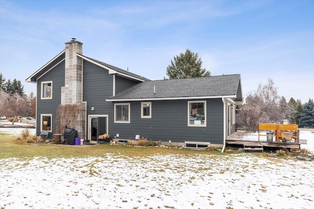 snow covered rear of property with a wooden deck