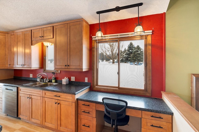 50 Stonecrest Dr, Kalispell, MT 59901 - kitchen featuring stainless steel dishwasher, built in study area, brown cabinets, pendant lighting, and dark countertops