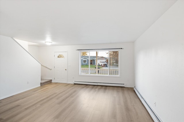 unfurnished living room featuring baseboard heating and light hardwood / wood-style floors