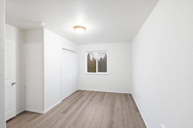 unfurnished bedroom with light hardwood / wood-style floors and a closet