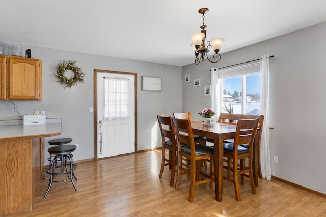 dining area with light hardwood / wood-style flooring and a chandelier