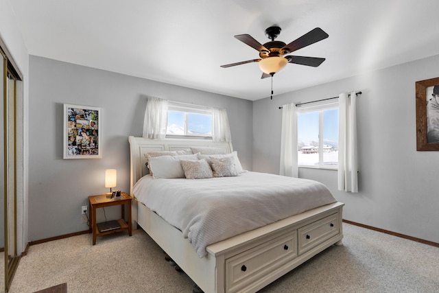 bedroom with light colored carpet, ceiling fan, and a closet