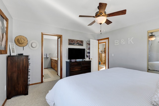 bedroom featuring ceiling fan, ensuite bath, and light carpet