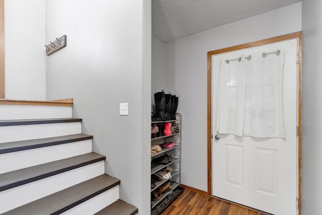 entrance foyer with hardwood / wood-style floors and a textured ceiling