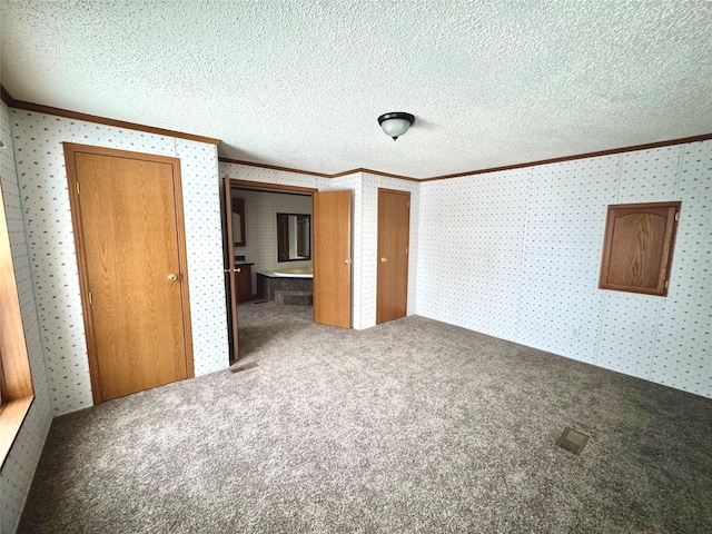 unfurnished bedroom featuring ornamental molding, carpet flooring, and a textured ceiling