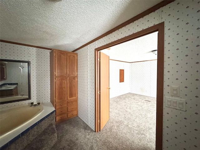 bathroom featuring crown molding, a bath, and a textured ceiling