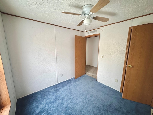 unfurnished bedroom with crown molding, ceiling fan, dark carpet, and a textured ceiling