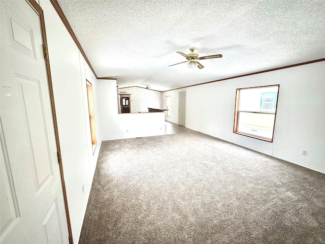 unfurnished living room featuring ornamental molding, vaulted ceiling, carpet flooring, and a textured ceiling