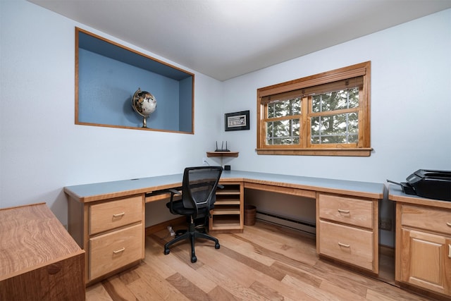 home office featuring a baseboard radiator, built in desk, and light hardwood / wood-style flooring