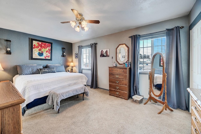 carpeted bedroom featuring ceiling fan and a textured ceiling