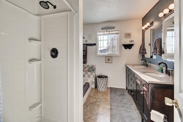 bathroom with vanity, a textured ceiling, and separate shower and tub